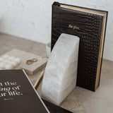 Limited edition Stone Rounded Bookends and a book on a table at Papier HQ.
