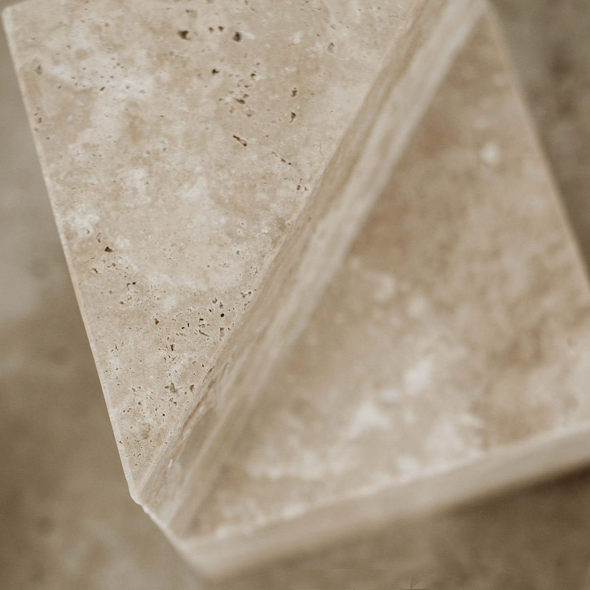 Close up of a travertine bookend showing the pitted stone surface and cut edges