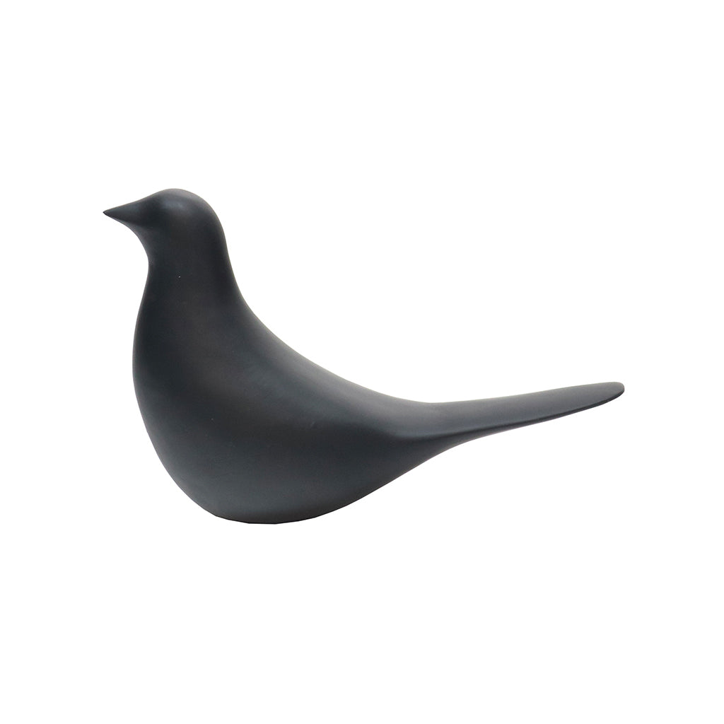 Matte black ceramic bird figurine in the same profile, long tail sweeping back, on white