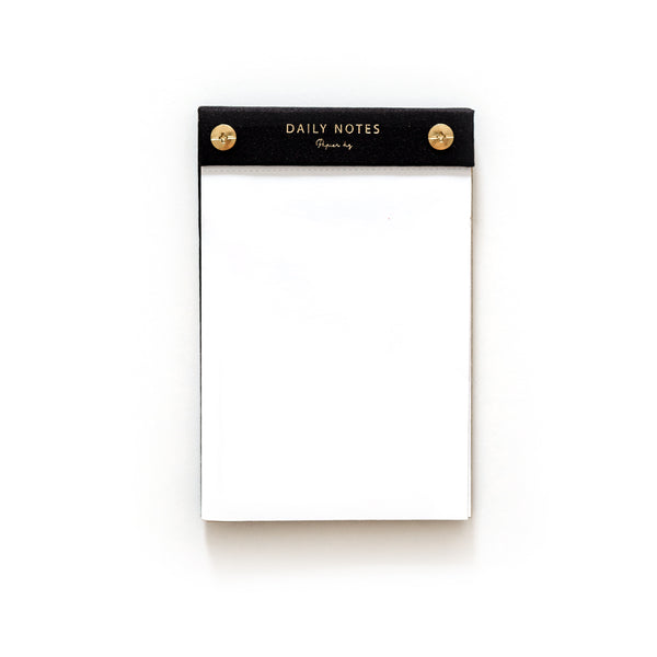 A limited edition black and gold Daily notes by Papier HQ on a white surface.