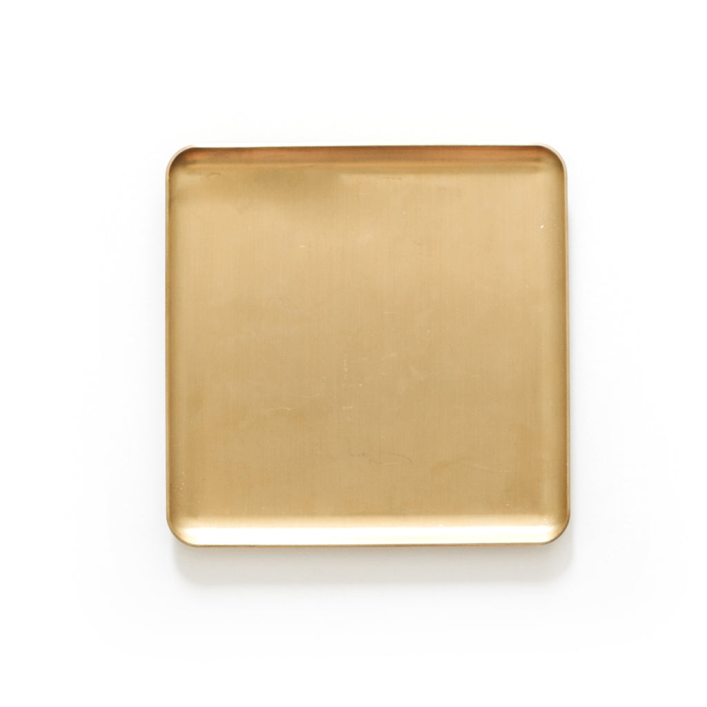 Solid polished brass desk tray styled with pen and notebook