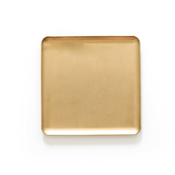 A square Papier HQ brass tray on a white surface.