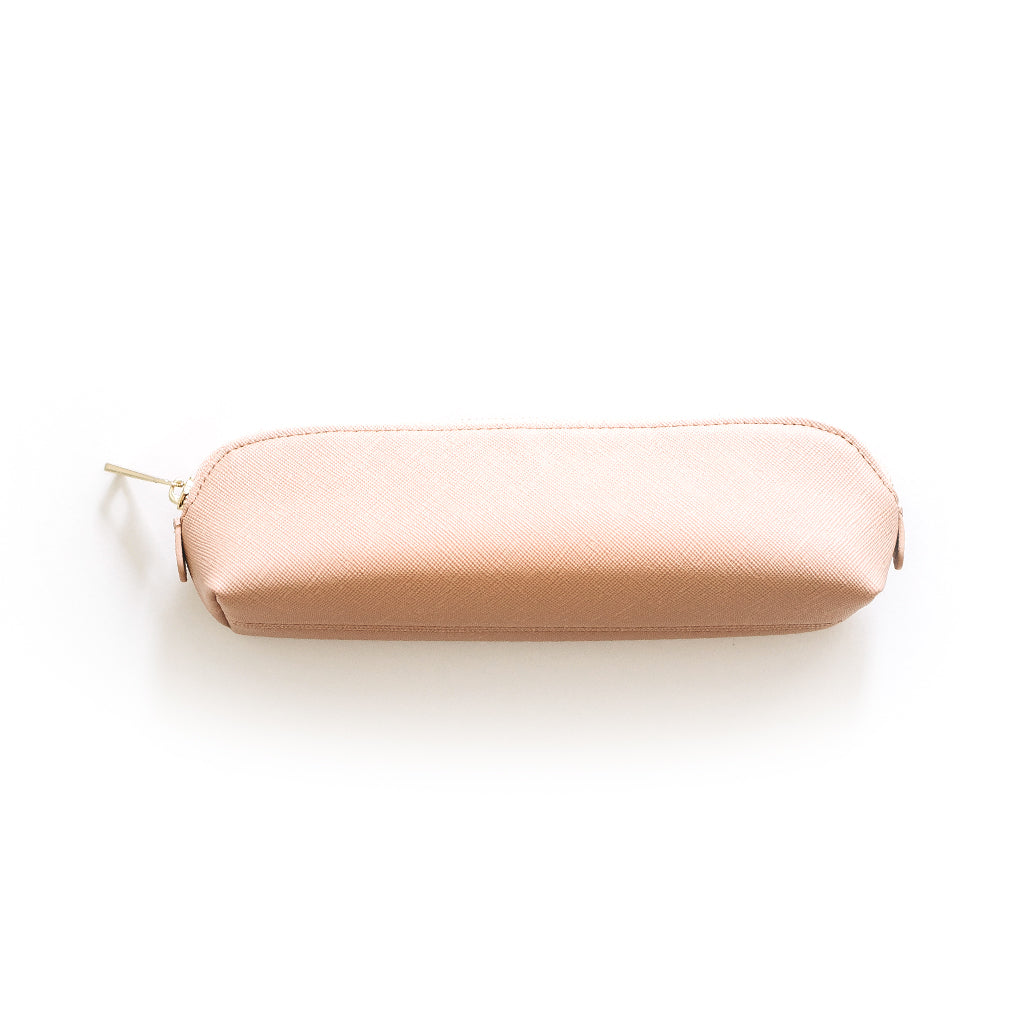 Pink saffiano leather pencil case with gold hardware styled on desk