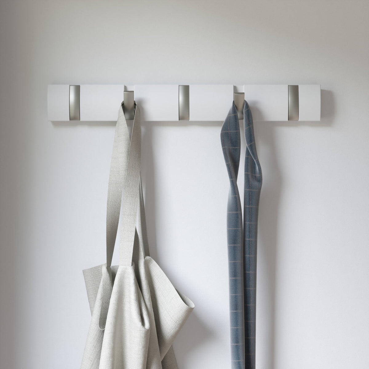 Umbra Flip 5 hook rack in white holding a linen coat and denim jacket