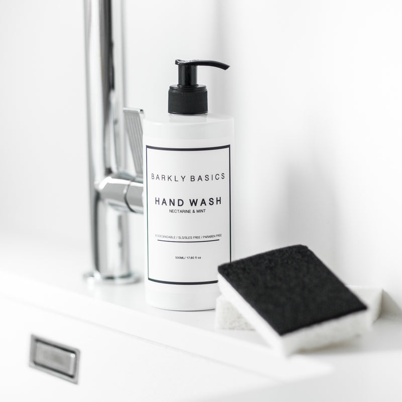 A bottle of Barkly Basics eco-friendly hand wash sits on a sink next to a sponge.
