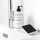 A designer Barkly Basics 1 Litre Hand Wash REFILL bottle enhances the decor of a sink area alongside a sponge.