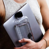 A woman holding a Slim Memobottle by MemoBottle.
