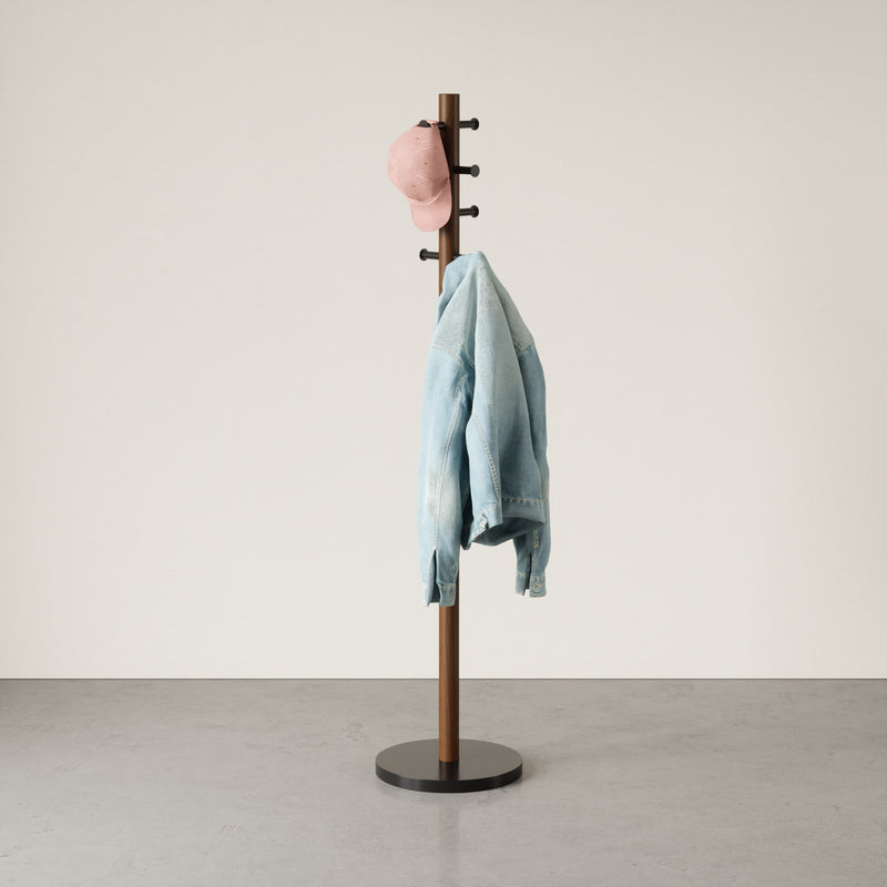 An Umbra Pillar Coat Rack providing storage for a jacket.