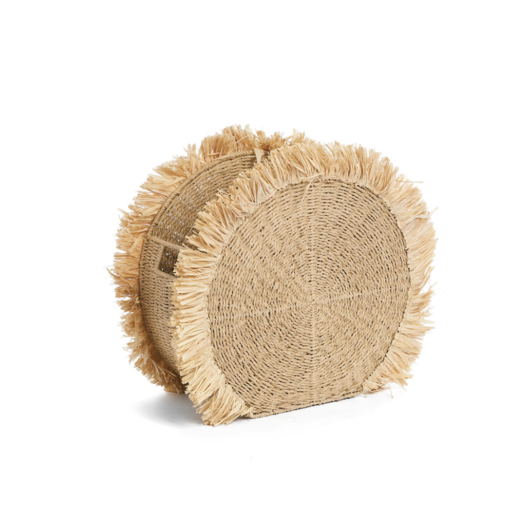 Large round raffia basket in natural straw with a fringed edge around the face