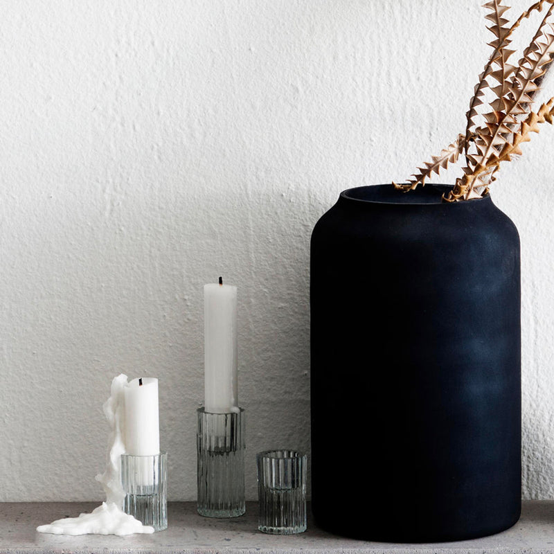 A modern silhouette of Zakkia's Ribb Candle Holder Set - Clear on a shelf.
