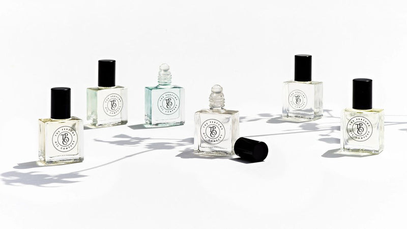 Five bottles of the Perfume Oil Collection Gift Set - Fresh sitting on a white surface, showcasing The Perfume Oil Company's floral fragrances.