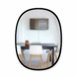 Umbra Hub oval mirror in black reflecting a dining table and chairs