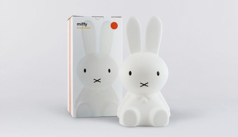 A medium-sized Miffy Star Light - DIMMABLE, MOOD LIGHTING lamp with a box in front of it, showcasing its distinctive design from Mr Maria.