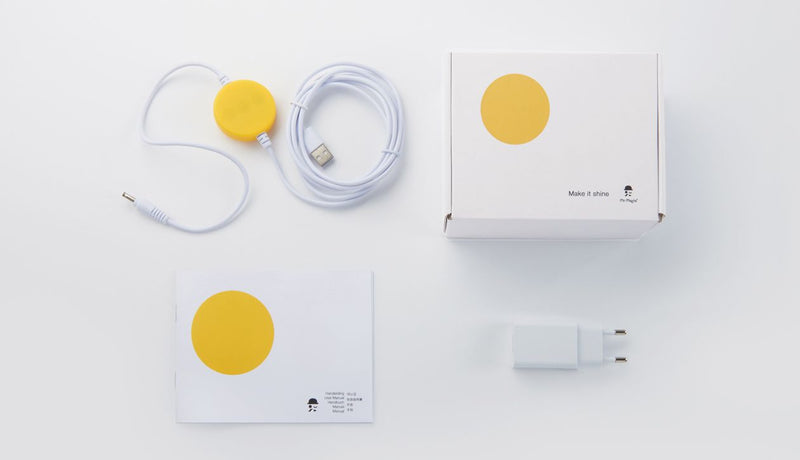 A medium-sized yellow box with a charger and a yellow dot, designed like a Miffy Star Light - DIMMABLE, MOOD LIGHTING lamp from Mr Maria.