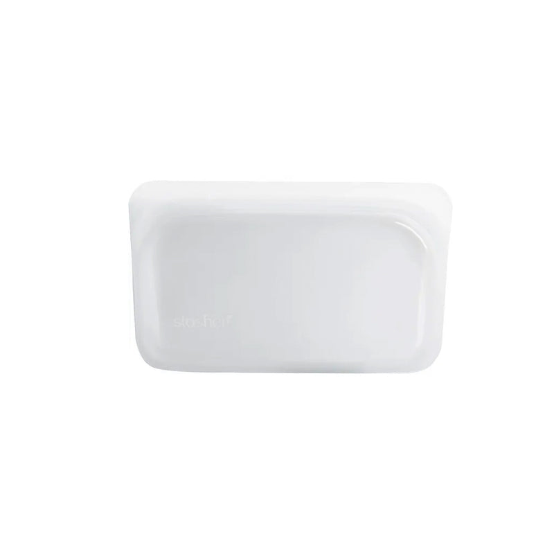 A white plastic SNACK container on a white surface, made by Stasher.
