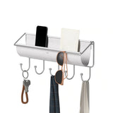 An Umbra wall-mounted metal rack for small accessories and storage, including hats, sunglasses, and other items.