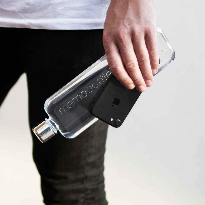 A person holding an iPhone and a MemoBottle Slim Memobottle for their daily water intake.