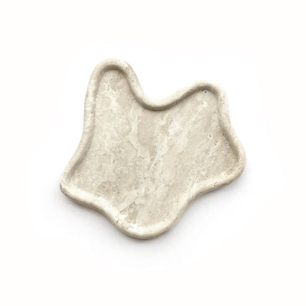 Travertine curved tray with organic sculptural shape styled on a console