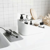 A bathroom sink with a GLAM HAIR TOOL ORGANIZER by Umbra.