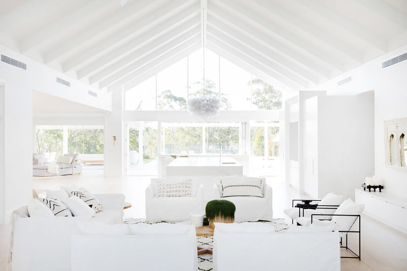 A white living room with a vaulted ceiling showcasing Three Birds Renovations: Dream Home How-To goodness.