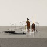 A GLAM HAIR TOOL ORGANIZER - Clear by Umbra, comb, and other items on a table.