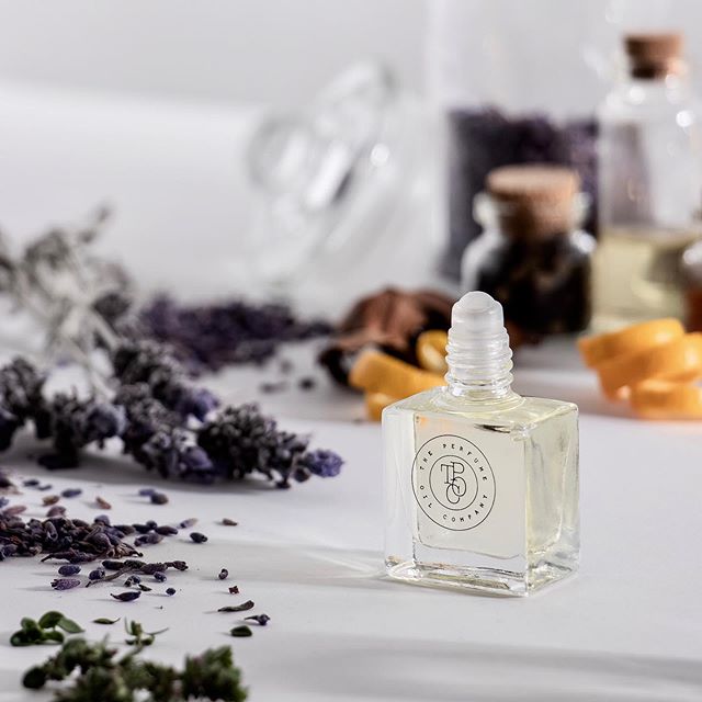 A SASS roll-on perfume oil bottle surrounded by herbs and spices, perfect for vegan-friendly fragrance refresh, inspired by Black Opium from YSL. Developed by The Perfume Oil Company.