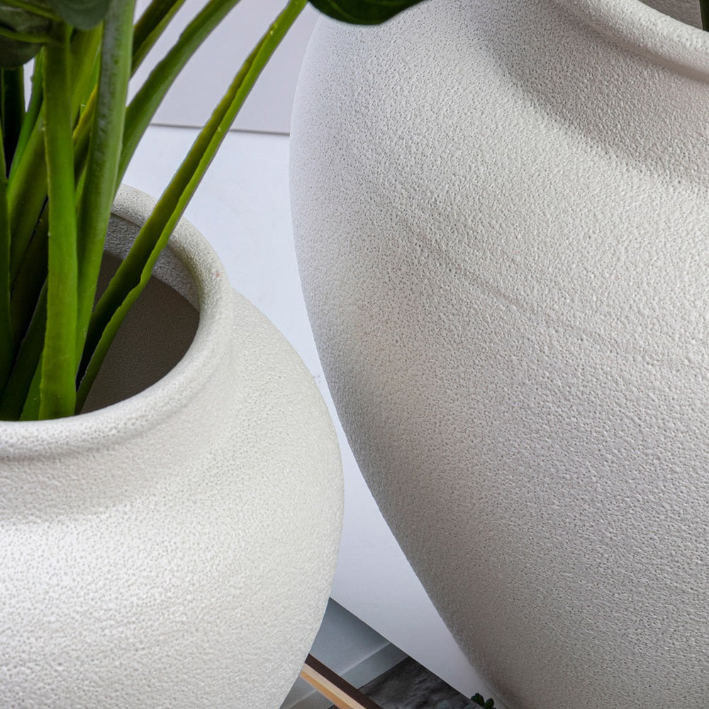 Close up of the small and large urn planters together, showing the textured matte white finish