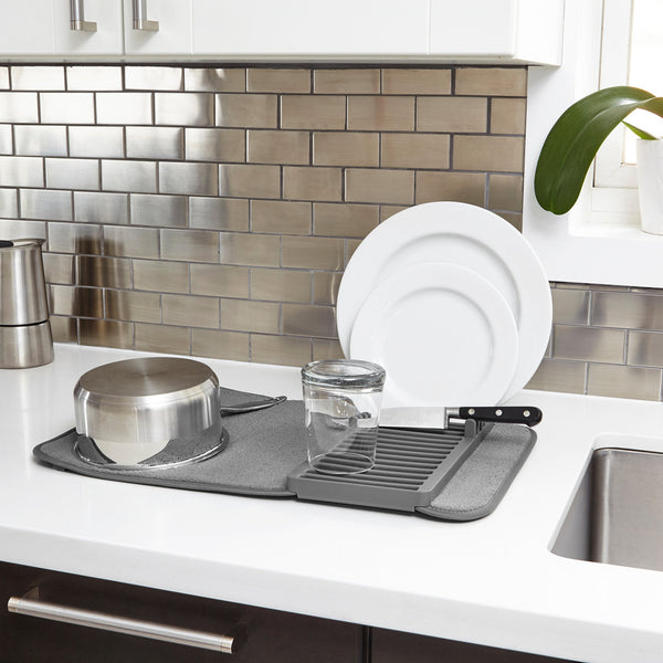 An Umbra Udry Drying Mat Mini with dishes on it and a dish drying rack.