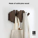 A stylish Umbra Picket Rail Wall Hook featuring flip hooks, serving as functional wall art, with a trendy tote bag hanging on it.
