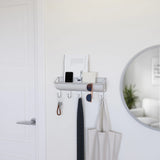 A small, Umbra wall-mounted HAMMOCK WALL ORGANIZER GREY featuring a mirror and coat rack for storage of small accessories.