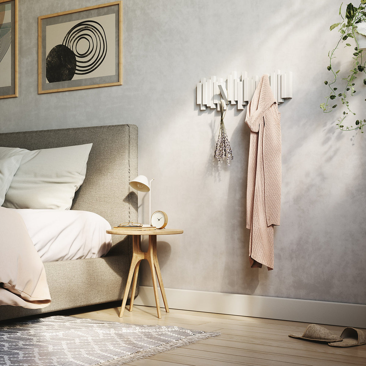 A bedroom with a Bed, a bedside table, and Umbra Sticks Multi Hook - White home organization options.