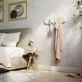 A bedroom with a Bed, a bedside table, and Umbra Sticks Multi Hook - White home organization options.