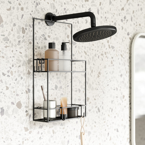 A bathroom with an Umbra Cubiko Shower Caddy and a shower head.