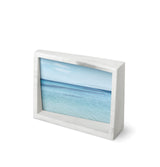 A modern Edge Marble Frame by Umbra with a picture of the ocean.