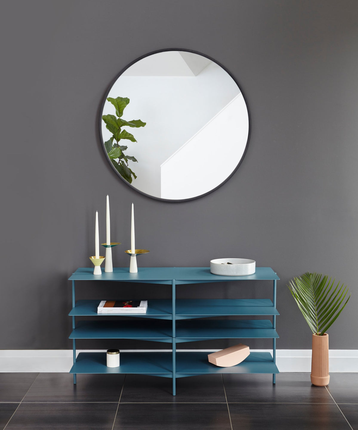 A modern blue dresser with an Umbra HUB MIRROR 45CM BLACK on top.