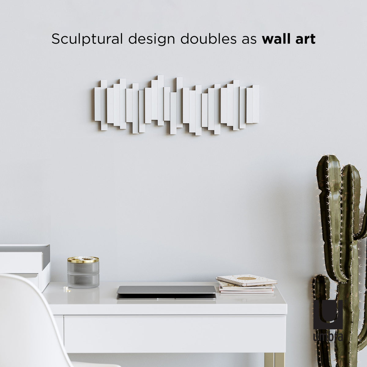 Umbra Sticks multi hook rack in white above a desk, sculptural wall art design