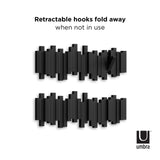 A black and white photo of a Umbra Sticks Multi Hook - Black home organization flip-down hooks.